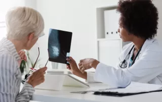 doctor explaining mammography x-ray of breast tissue to patient