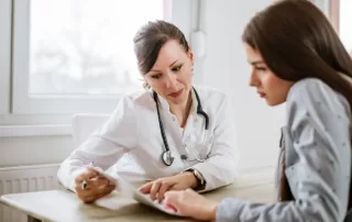 professional female doctor explaining treatment to middle age female patient